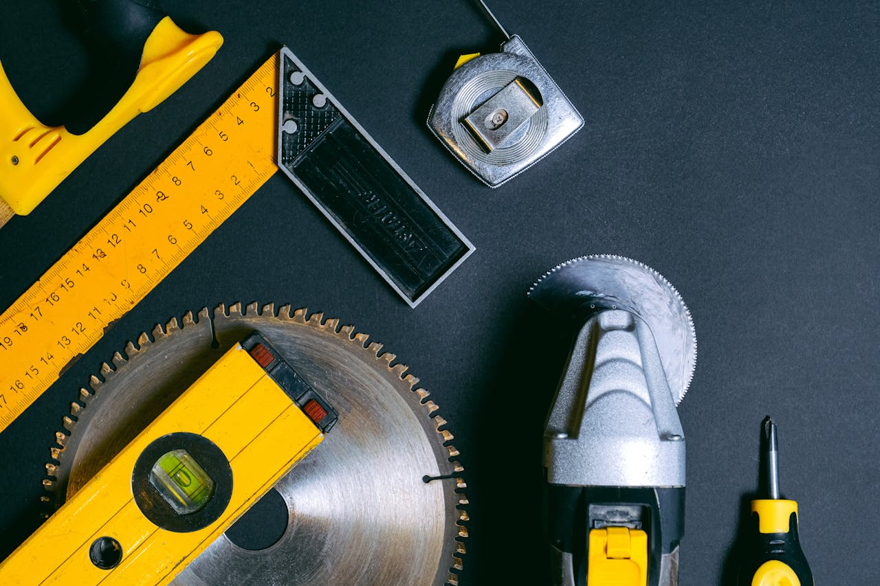 About A selection of construction hand tools arranged flat lay style on a dark surface. Ideal for industry themes.